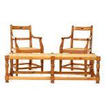 Pair of yellow wood and stink wood open arm elbow chairs, each having a sling seat and standing on