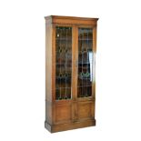 Early 20th Century oak cabinet bookcase, the upper section fitted five shelves enclosed by a pair of