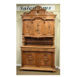 Early 20th Century Continental carved light oak two section cupboard, the upper section having a