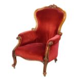 Victorian carved walnut framed drawing room chair upholstered in red velour and standing on cabriole