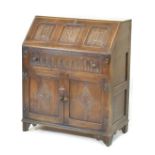 Oak bureau, the fall flap with linen fold decoration, one long drawer and cupboard doors below