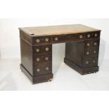 Edwardian oak double pedestal kneehole desk having an inset leather writing surface, fitted nine