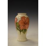 Modern Moorcroft baluster shaped vase decorated with the Hibiscus pattern on an off-white ground