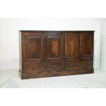 Late 19th/early 20th Century oak four door cupboard having fielded panels and two short drawers
