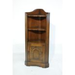 Reproduction oak standing corner cupboard fitted three open shelves with a cupboard door below and