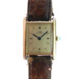 Must de Cartier silver gilt tank quartz wristwatch, the ivory dial having Roman numerals, on a brown