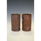 Pair of Chinese carved bamboo brush pots, each typically decorated with figures in a woodland