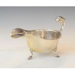 George V silver sauce boat having an acanthus scroll handle and standing in triple pad feet,