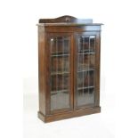 1920's period oak cabinet bookcase fitted four shelves enclosed by a pair of leaded glass doors