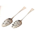 Matched pair of George III silver berry spoons, London 1804 and 1817, the bowls with later embossing