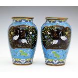 Pair of Japanese cloisonné ovoid vases, each having two reserves depicting storks amongst foliage