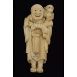 Japanese carved ivory netsuke, signed Yoshitomo and depicting a monkey trainer, a drum before him