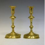 Pair of mid 18th Century brass candlesticks, each having a double knopped stem and standing on a
