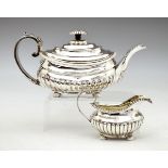 George III silver teapot having a gadrooned edge, half reeded body, acanthus scroll handle, standing