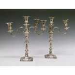 Pair of Elizabeth II silver three branch candelabra, each standing on a knopped stem and square