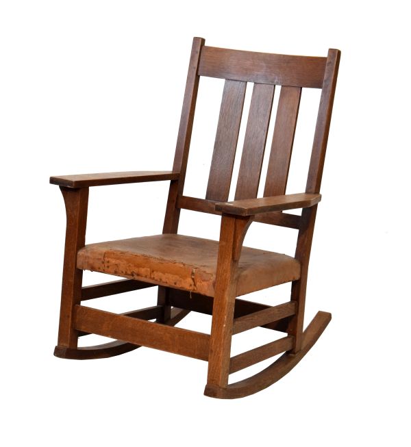 Gustav Stickley oak ladder back rocking chair having a triple lath back, wide flat arms, stuffed