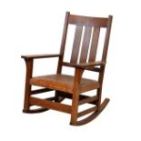 Gustav Stickley oak ladder back rocking chair having a triple lath back, wide flat arms, stuffed