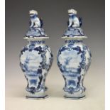 Pair of Dutch Delft baluster shaped vases and covers, each having blue and white painted