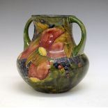 William Moorcroft baluster shaped two handled vase decorated with the Pomegranate pattern on a green