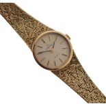 Omega - De Ville - Lady's 9ct gold wristwatch with integrated textured bracelet, the dial with