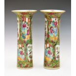 Pair of Cantonese Famille Rose cylindrical vases typically decorated with alternate reserves