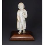 19th Century European carved ivory figure of a standing Buddha, 11.5cm high, on a later mahogany