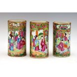 Three Cantonese Famille Rose cylindrical brush pots, typically decorated with alternate reserves