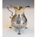 18th Century silver cream jug having an ogee scroll handle, later embossed decoration and standing
