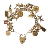 9ct gold padlock and yellow metal charm bracelet of curb link design set with approximately 20