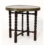 Eastern brass topped occasional table standing on a beech folding barley twist base Condition: