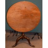 George III mahogany circular snap-top supper table standing on a turned pillar and tripod base