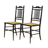 Pair of late Victorian ebonised bedroom chairs, each having a rod back, stuffed seat and standing on