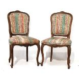 Pair of French carved mahogany framed side chairs, each upholstered in striped fabric and standing