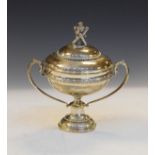 George V silver two handled cup and cover, the cover surmounted by the cast figure of St Andrew with