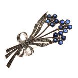 Diamond and sapphire floral spray brooch modelled as three blue flowers, each of five petals on