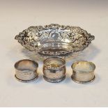 Edwardian silver bon bon dish of pierced wavy oval form, together with three later napkin rings,