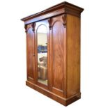 Victorian mahogany three door wardrobe, the centre mirror panel door and right hand blind panel door