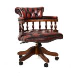 Reproduction mahogany finish framed tub shaped swivel desk chair upholstered in deep buttoned red