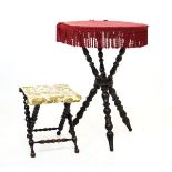 Victorian gypsy table having a typical deep red tasselled velour top and standing on a bobbin turned