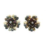 Pair of unmarked yellow metal clip on earrings, each of flower head design with diamond and ruby