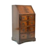 Reproduction mahogany bureau fitted fall flap enclosing a partially fitted interior, four long