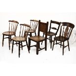 Three Victorian beech stickback kitchen chairs, each having a circular seat and standing on