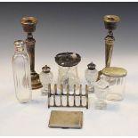 Group of assorted silver to include; a pair of silver table candlesticks, cigarette case, toast