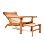 Modern Eastern plantation type chair having a rattan seat, integral foot rest and standing on square