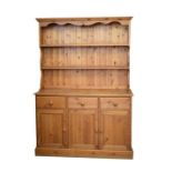 20th Century stained pine high dresser with moulded cornice and apron over two shelves, planked