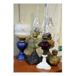 Six assorted paraffin lamps, most with glass bodies including three with metal bases Condition: