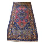 Modern Middle Eastern rug having geometric decoration on a deep red and blue ground within multi