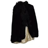 Early 20th Century black velvet cape with silk lining and trim together with a matching bonnet