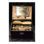 Edwardian wine morocco cased ivory dressing set comprising: boot pull, pair of hand brushes, pair of
