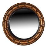 Gilt framed circular convex wall mirror having typical ball decoration and with a reeded ebonised